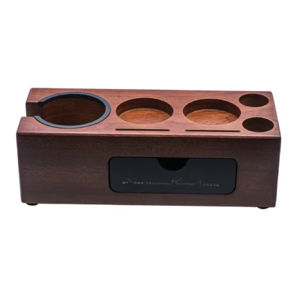 Espresso wood tamper station One Station, Endless Functionality The Nicepring 8-in-1 Tamping Station is a multifunctional solution for both storage and tamping. Designed to streamline your coffee-making process, it holds espresso portafilters, tampers, distributors, stirrer needles, puck screens, brushes, and other essential accessories. By keeping your tools organized and providing a stable tamping base, it enhances both coffee extraction quality and barista satisfaction. **Adjustable Height for Precision Tamping** Featuring two interchangeable adapters for 51-54mm and 58mm portafilters, this station adapts easily to different sizes. The adjustable screw mechanism ensures your portafilter is positioned at a perfect 90° angle, allowing for consistent and effortless tamping every time. **Magnetic Storage for Easy Organization** The magnetic storage box securely attaches to the tamping base, providing a convenient place to store small accessories like brushes, needles, and puck screens. Keep your tools neatly organized and within reach, making your espresso routine more efficient. **Crafted from Premium Sapele Wood** Constructed from high-quality natural Sapele wood, the tamping station is built to last while adding an elegant touch to your coffee bar. Its sturdy build provides a solid base for tamping, combining practicality with aesthetics to elevate your coffee-making experience.